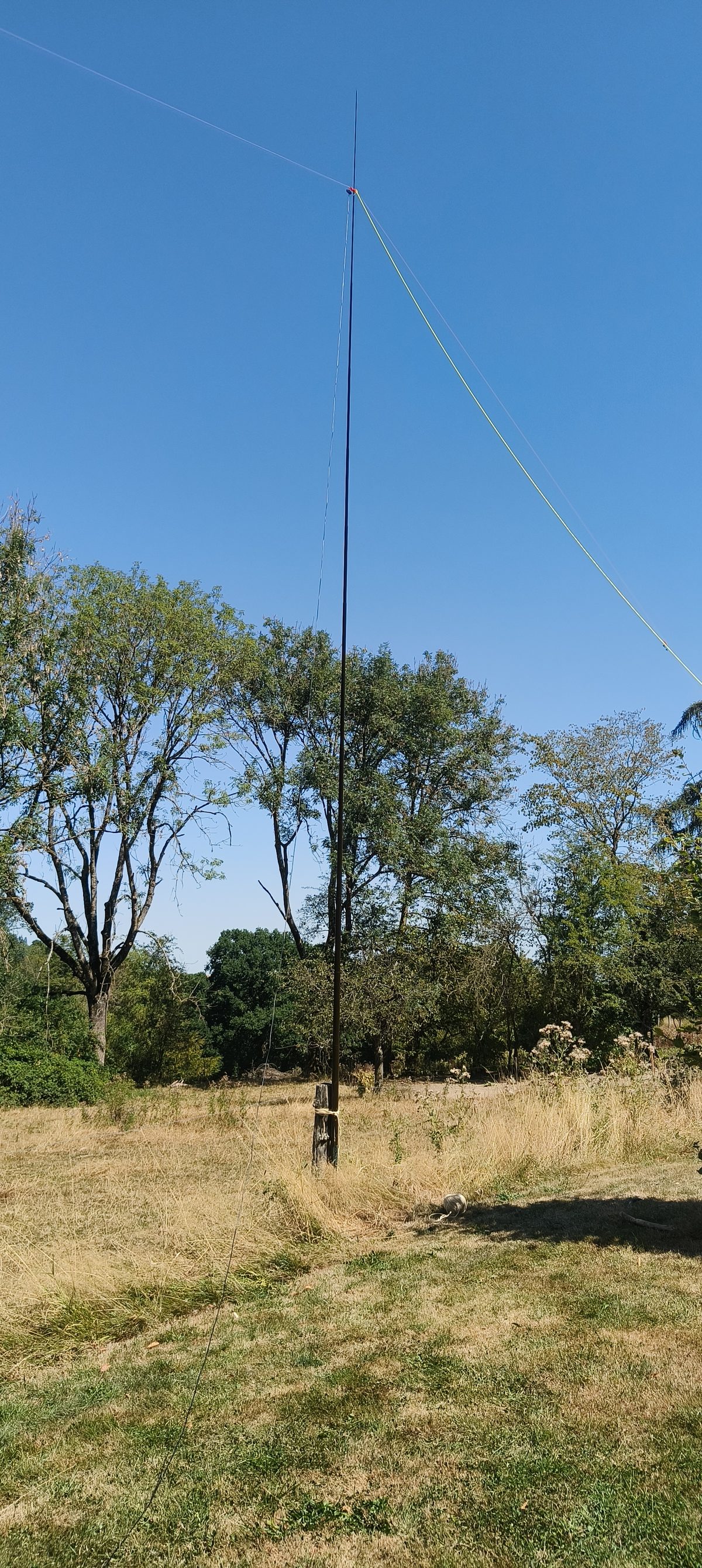 Tactical 7000hds mast erected in a field, supporting the Band Hopper IV linked dipole